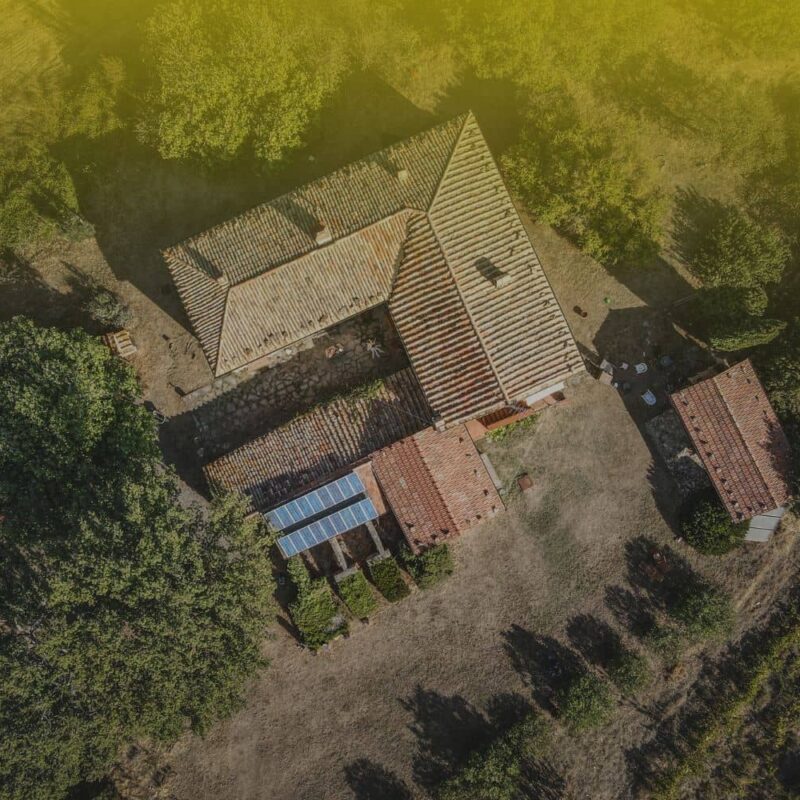 Aerial view of a residential home with solar panels, illustrating a key factor in how to calculate ROI on rental property for real estate investors.