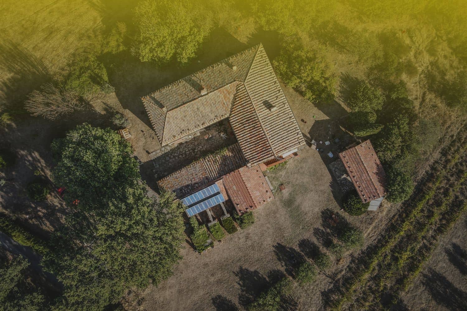 Aerial view of a residential home with solar panels, illustrating a key factor in how to calculate ROI on rental property for real estate investors.
